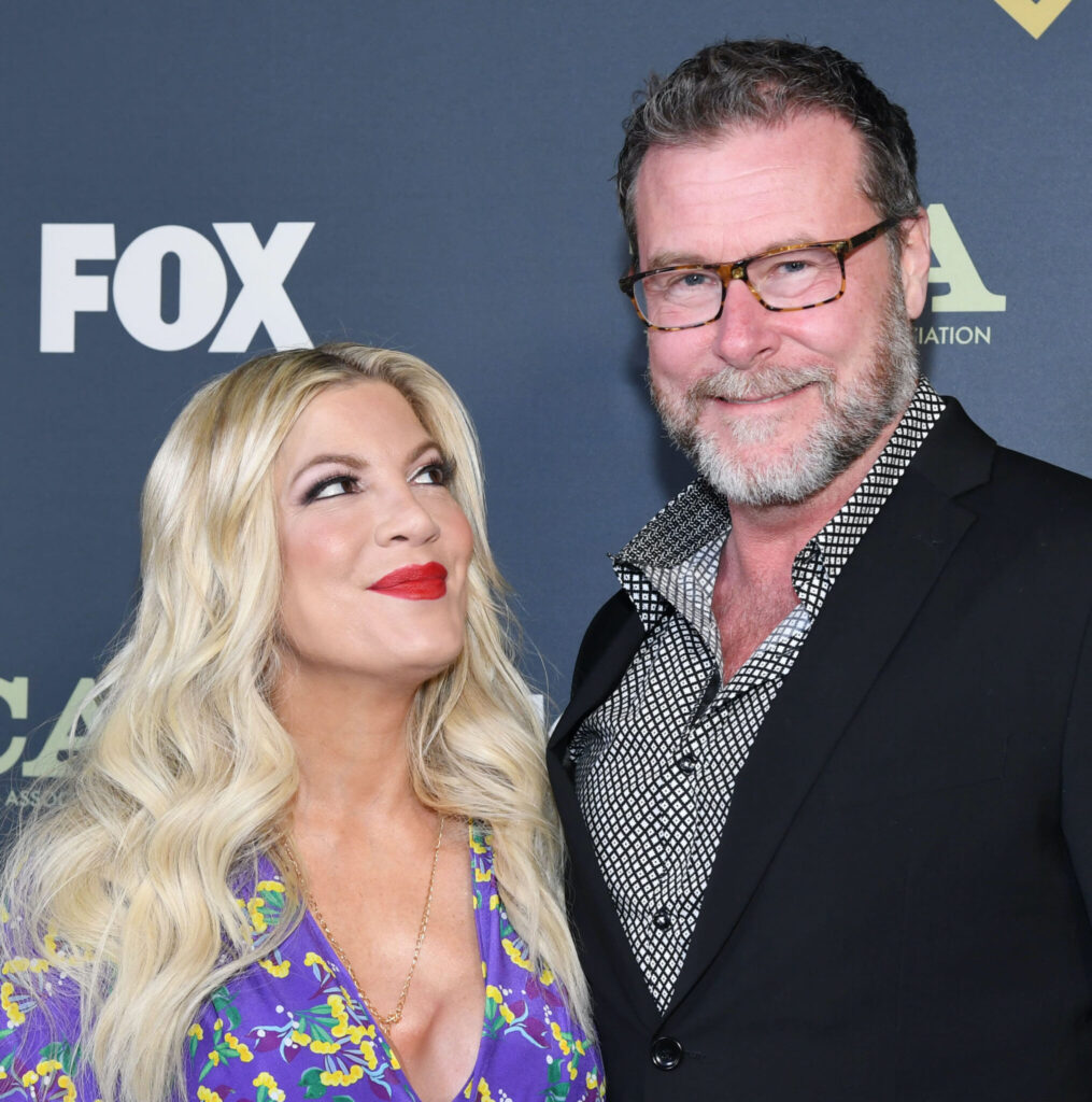 Tori Spelling and Dean McDermott stand together on the red carpet, with Tori gazing adoringly at him.