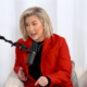 Savannah Chrisley wears a red jacket in a white room. Her hairstyle suggests someone twice her age.