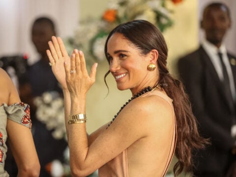Meghan, Duchess of Sussex, gestures as she arrives with Britain's Prince Harry (unseen), Duke of Sussex, during their visit at the Lightway Academy in Abuja on May 10, 2024.