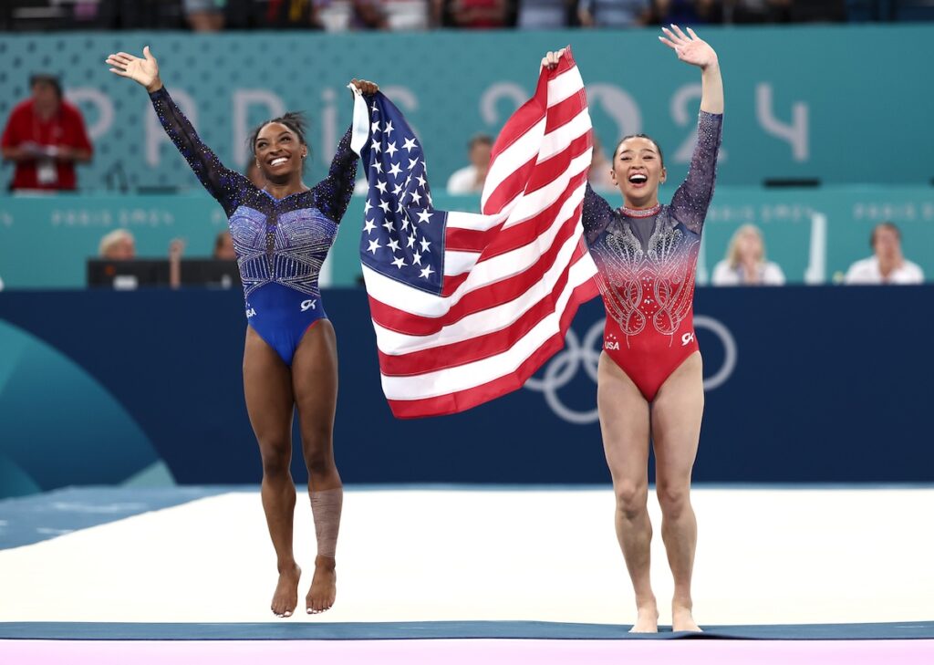  Gold medalist Simone Biles (L) and Bronze medalist Sunisa Lee of Team United States celebrate with the American flag after competing in the Artistic Gymnastics Women's All-Around Final on day six of the Olympic Games Paris 2024 at Bercy Arena on August 01, 2024 in Paris, France. 