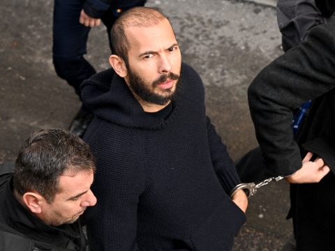 British-US influencer Andrew Tate arrives handcuffed and escorted by police at a courthouse in Bucharest on February 1, 2023 to hear the court decision on his appeal against pre-trial detention for alleged human trafficking, rape and forming a criminal group.