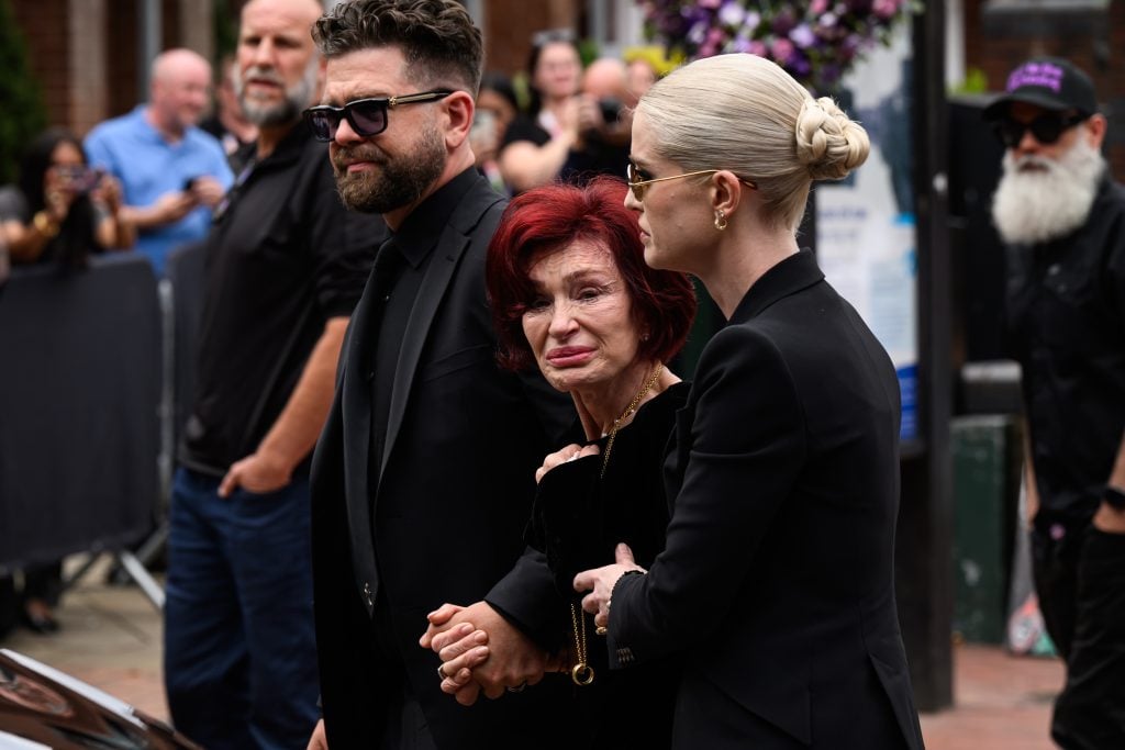 Džeks Osburns, Šarons Osburns un Kellija Osbourne aiziet pēc cieņas skatīšanas uz vēlu Ozzy Osbourne no faniem, kad viņa apbedīšanas korts ceļo pa savu dzimto pilsētu Birmingemu 2025. gada 30. jūlijā Birmingemā, Anglijā.