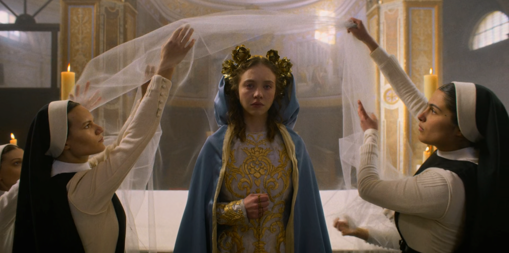 Um choroso Sydney Swinei, vestido como um ícone religioso católico, no filme 'Imaculado'.