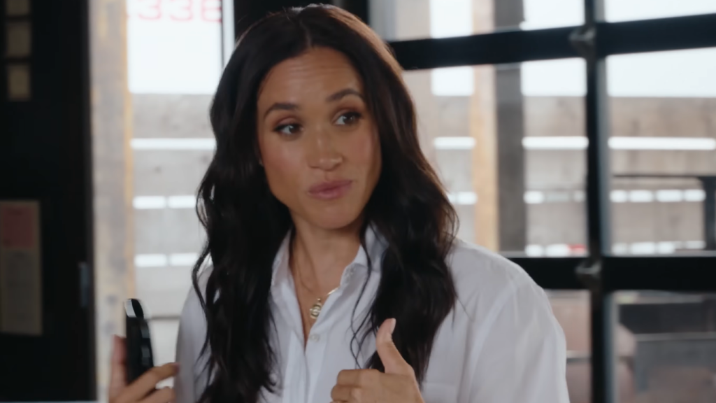 Meghan Markle in a light periwinkle blouse.