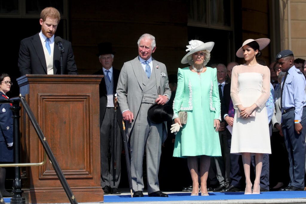 Prince Harry speaks near King Charles in 2018.