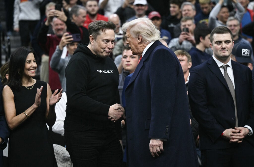 Elon Musk is dressed so normally as he shakes hands with Donald Trump.