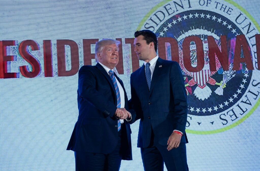 US President Donald Trump shakes hands with Charlie Kirk, head of Turning Point USA, before addressing the Turning Point USA's Teen Student Action Summit in Washington, DC, on July 23, 2019. 