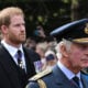Britain's King Charles III and Britain's Prince Harry, Duke of Sussex walk behind the coffin of Queen Elizabeth II, adorned with a Royal Standard and the Imperial State Crown and pulled by a Gun Carriage of The King's Troop Royal Horse Artillery, during a procession from Buckingham Palace to the Palace of Westminster, in London on September 14, 2022.