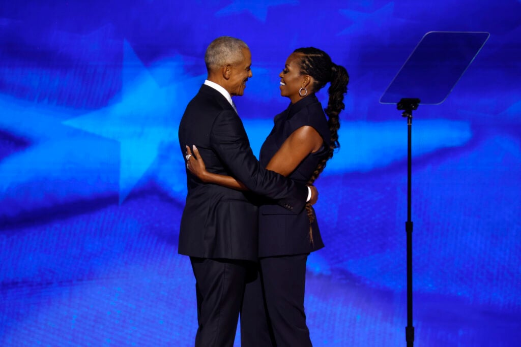 Former U.S. President Barack Obama (L) greets former first lady Michelle Obama as he arrives to speak on stage during the second day of the Democratic National Convention at the United Center on August 20, 2024 in Chicago, Illinois.