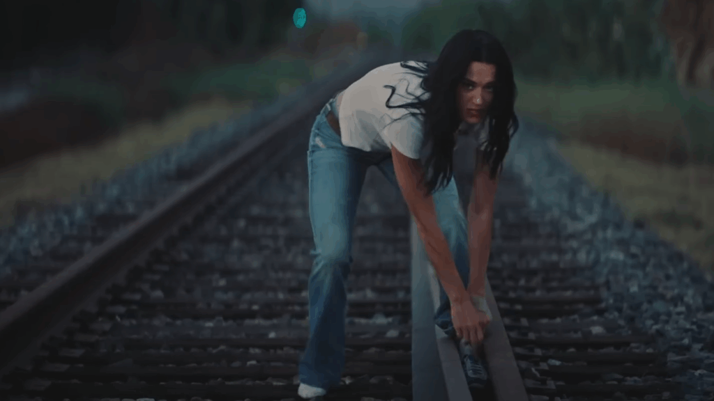 Katy Perry appears trapped on the train tracks during her "Bandaids" music video.