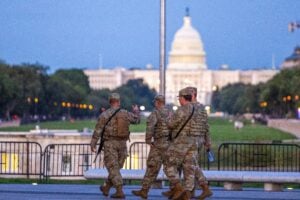 National Guard members patrol carrying weapons with the U.S. Capitol Building in the distance on August 25, 2025 in Washington, DC.