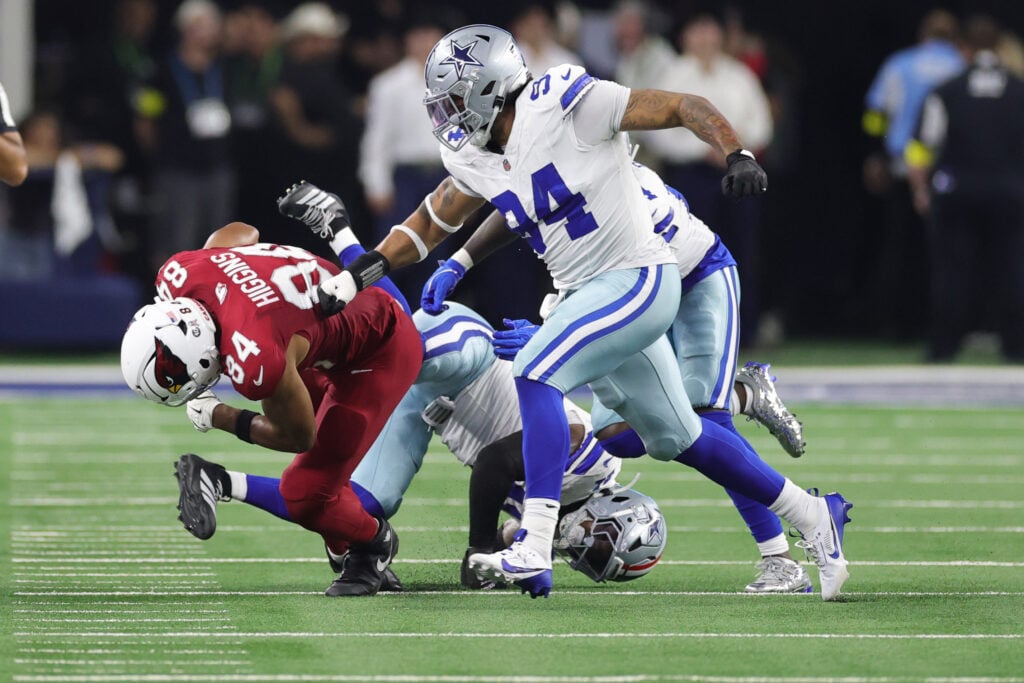 Elijah Higgins #84 of the Arizona Cardinals rushes ahead of Marshawn Kneeland #94 of the Dallas Cowboys during the second quarter in the game at AT&T Stadium on November 03, 2025 in Arlington, Texas.