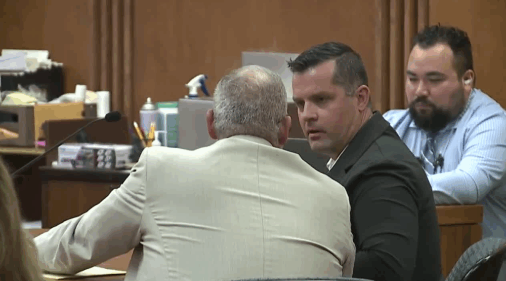 The late Christopher Scholtes consults his attorney during his trial.