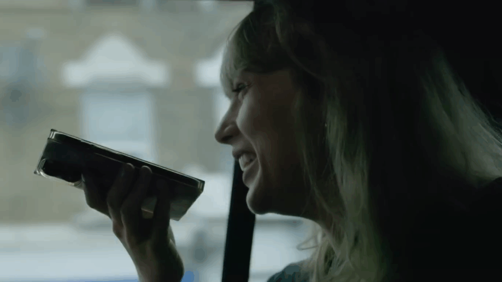 Taylor Swift sits in the back of an SUV and talks to her man on speakerphone.