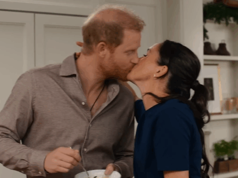 Prince Harry and Meghan Markle share a kiss.