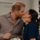 Prince Harry and Meghan Markle share a kiss.