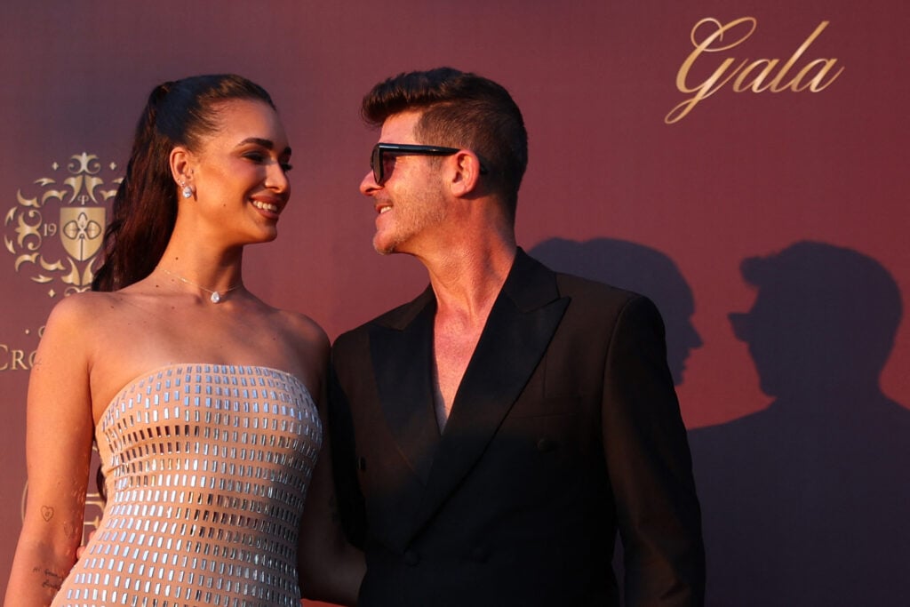 Robin Thicke and April Love Geary pose in July 2025.