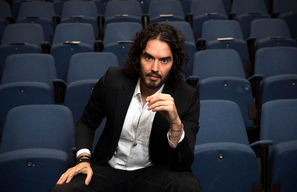 Russell Brand poses for photographs as he arrives to deliver The Reading Agency Lecture at The Institute of Education on November 25, 2014 in London, England. 