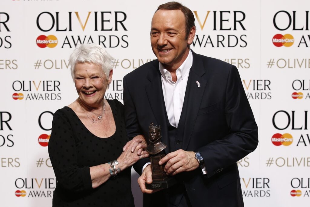 US actor, producer and director Kevin Spacey poses with a special award recognising his contribution to British theatre during his tenure as Artistic Director of The Old Vic with British actress Judi Dench during the Lawrence Olivier Awards for theatre at the Royal Opera House in central London on April 12, 2015.