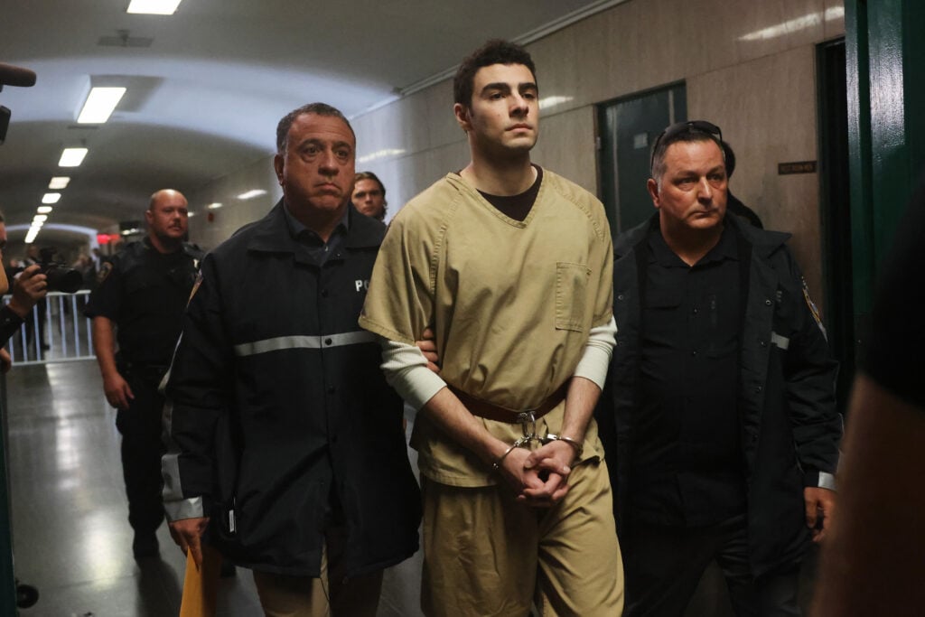 Luigi Mangione está acompañado por la policía mientras sus abogados presionan para que se desestimen los cargos estatales de asesinato en relación con el asesinato del director ejecutivo de UnitedHealthcare, Brian Thompson, en el Tribunal Penal de Manhattan el 16 de septiembre de 2025 en la ciudad de Nueva York. 