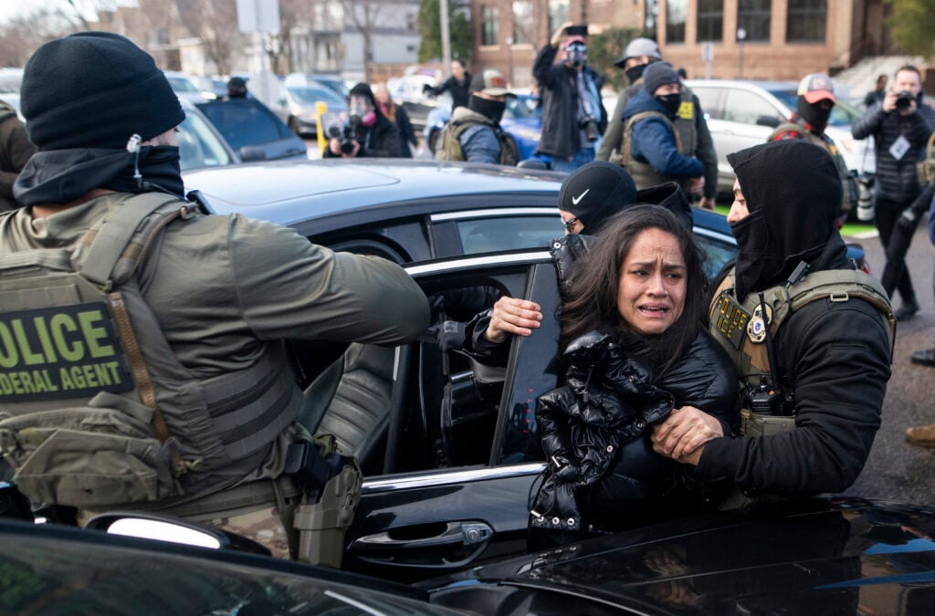 ICE agents detain a woman after pulling her from a car on January 13, 2026 in Minneapolis, Minnesota.