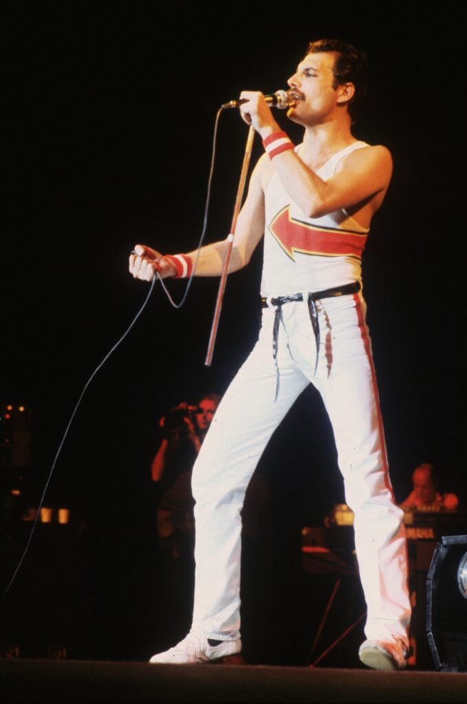 Freddie Mercury (1946 - 1991), lead singer of 70s hard rock quartet Queen, in concert at Leeds Football Club.