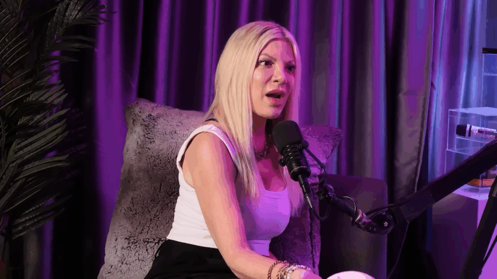 Tori Spelling habla bajo una hermosa iluminación violeta.