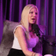 Tori Spelling speaks under beautiful purple lighting.
