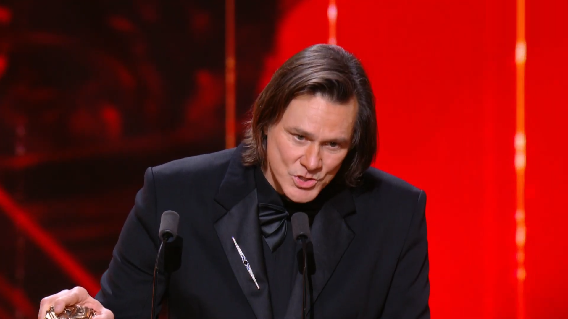 Jim Carrey speaks on stage.