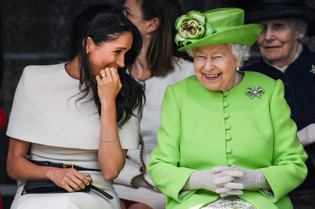 Queen Elizabeth II sits and laughs with Meghan, Duchess of Sussex during a ceremony to open the new Mersey Gateway Bridge on June 14, 2018 in the town of Widnes in Halton, Cheshire, England.  