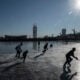 People play hockey on the frozen ice near the National Stadium at Olympic Park on January 13, 2022 in Beijing, China.