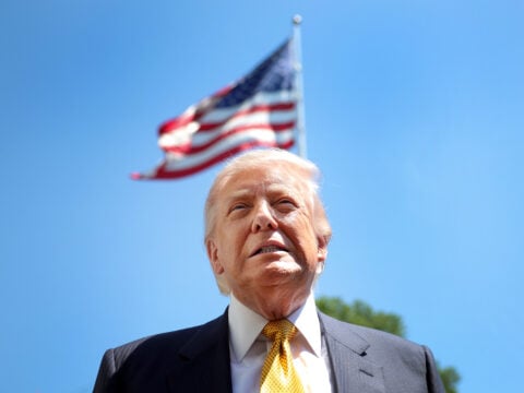 U.S. President Donald Trump speaks in front of the American flag to the press as he departs the White House on May 12, 2026 in Washington, DC.
