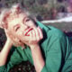 Actress Marilyn Monroe poses for a portrait laying on the grass in 1954 in Palm Springs, California.