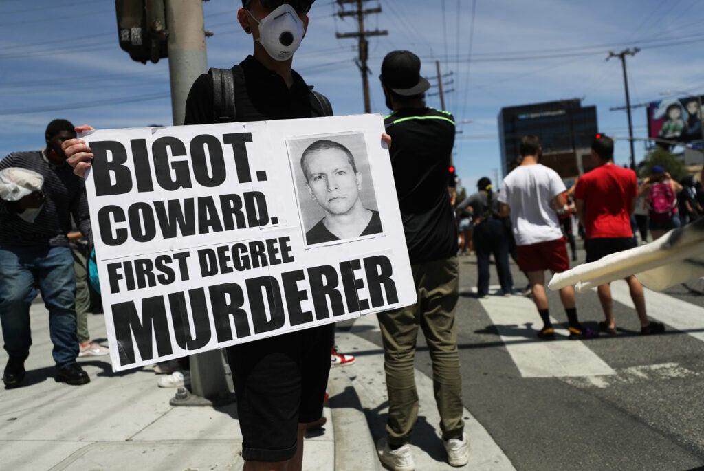 A protester holds a sign with a photo of former Minneapolis police officer Derek Chauvin during demonstrations following the death of George Floyd on May 30, 2020 in Los Angeles, California. 