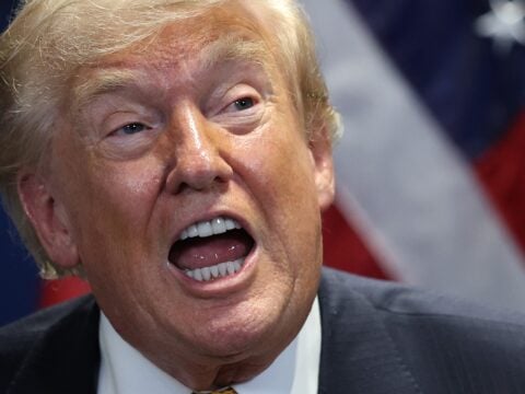 Donald Trump speaks, mouth wide open.