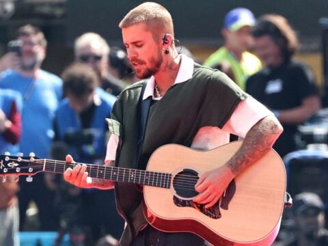 Justin Bieber holds his guitar on stage for the 2026 World Cup, a soccer event.