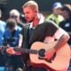 Justin Bieber holds his guitar on stage for the 2026 World Cup, a soccer event.