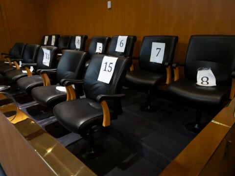 An empty jury box in a pre-trial courtroom.