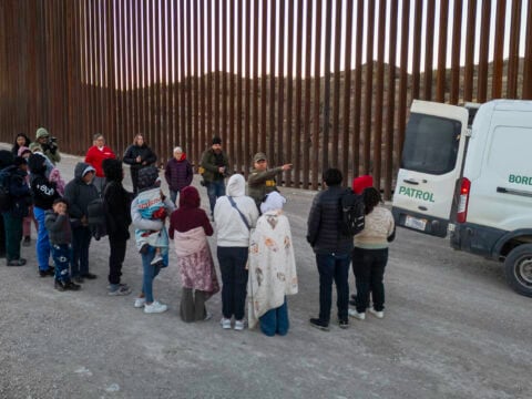 Immigrants wait to be transported by U.S. Border Patrol agents after crossing the U.S.-Mexico border on January 20, 2025 near Sasabe, Arizona.