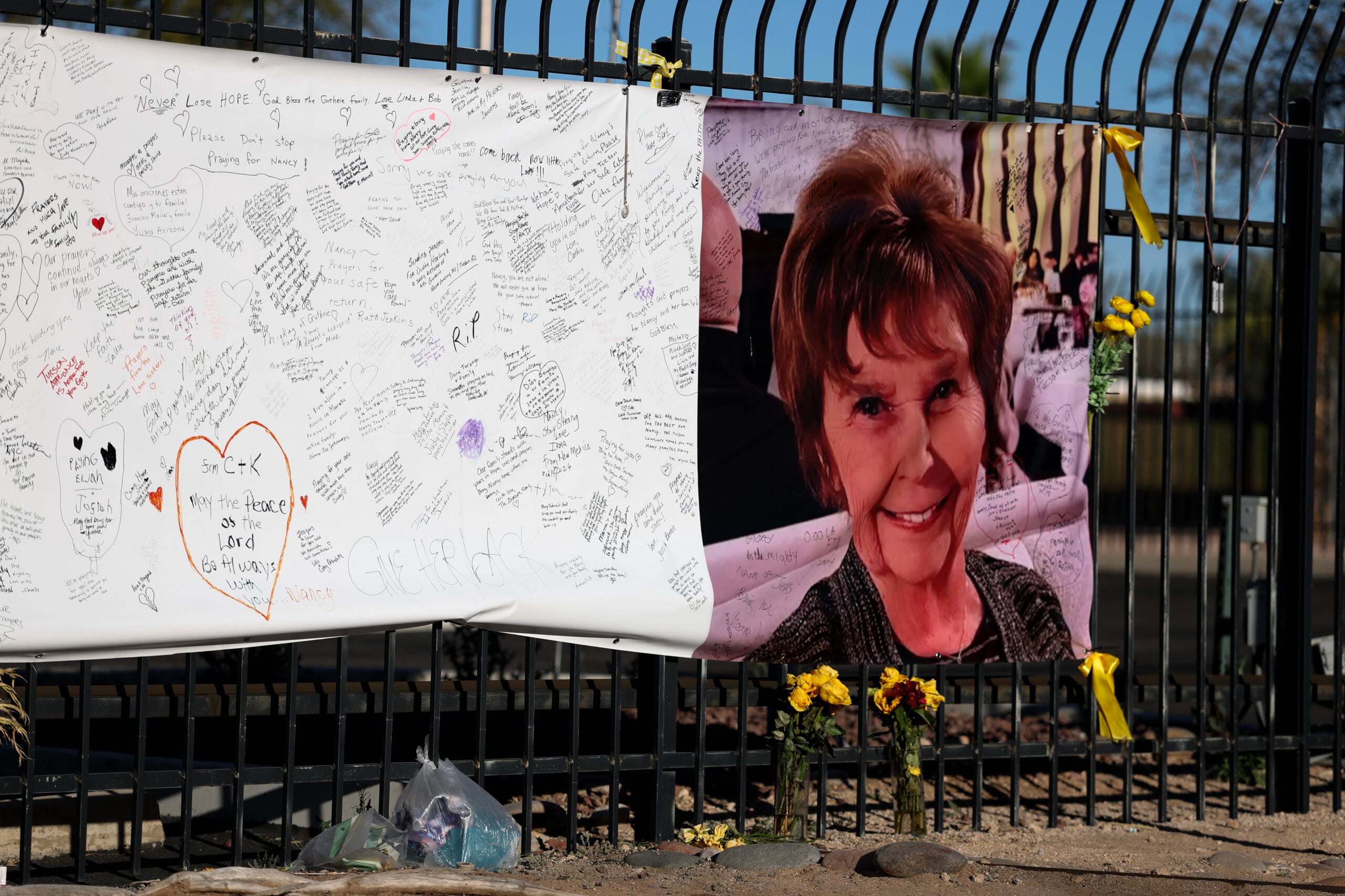 A photograph of Nancy Guthrie is seen on a sign that people can leave messages on February 26, 2026, in Tucson, Arizona.