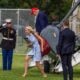 U.S. President Donald Trump steps off Marine One along with Natalie Harp, aide to U.S. President Donald Trump after landing at the Ellipse near the White House on August 16, 2026 in Washington, DC.