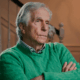 Henry Winkler in a lime green sweater but his arms crossed uncomfortably.