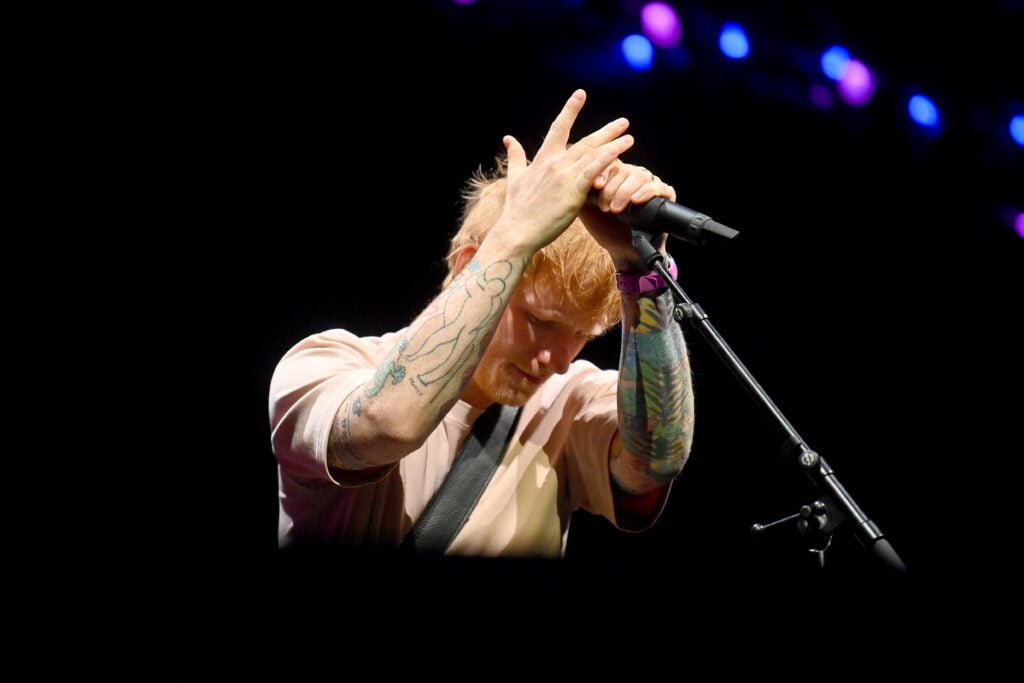 Ed Sheeran looks down while playing in December 2025.