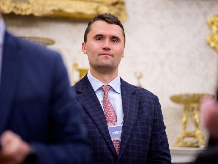 Turning Point USA co-founder Charlie Kirk stands in the back of the room as U.S. President Donald Trump speaks during a swearing in ceremony for interim U.S. Attorney for Washington, D.C. Jeanine Pirro in the Oval Office of the White House on May 28, 2025 in Washington, DC.
