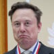 Elon Musk frowns while wearing an award in October 2026.