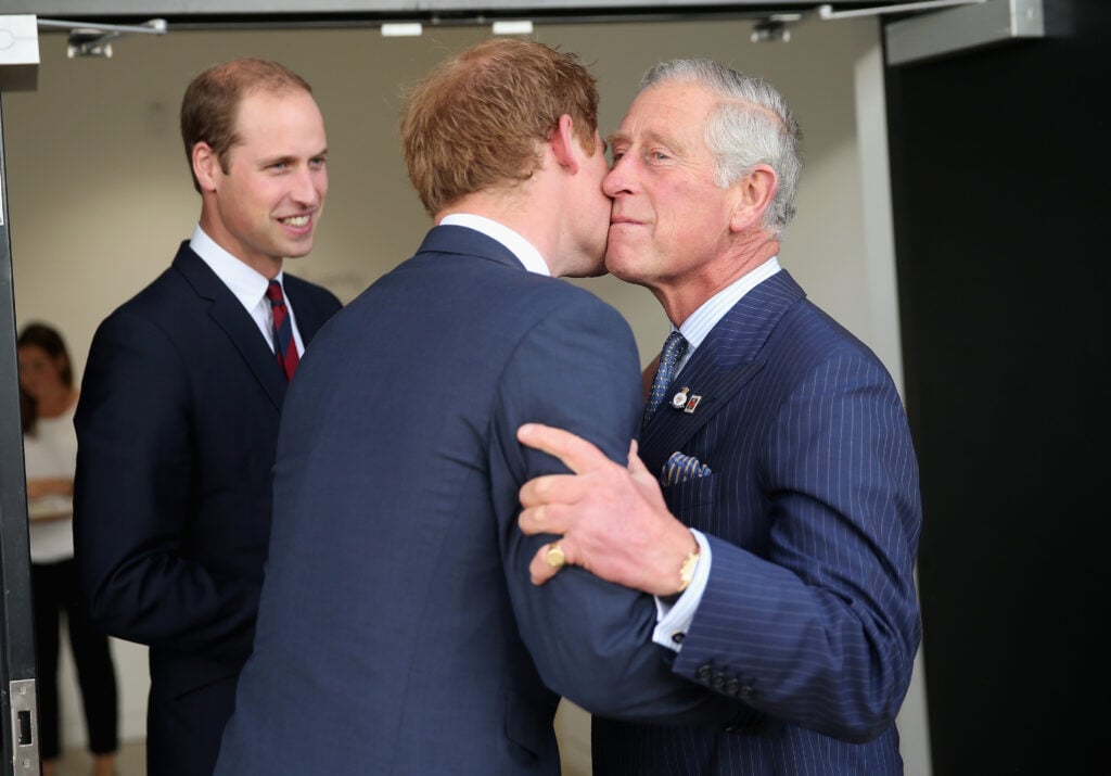 Prince Charles, Prince of Wales kisses his son Prince Harry as Prince William, Duke of Cambridge looks on ahead of the Invictus Games Opening Ceremony at Queen Elizabeth II Park on September 10, 2014 in London, England. 
